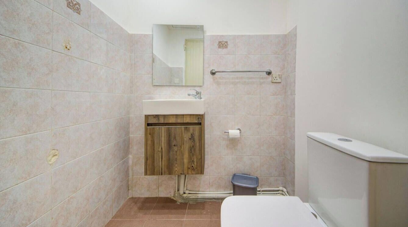 Une salle de bain équipée d’un lavabo, d’un miroir, d’un porte-serviettes et de toilettes.