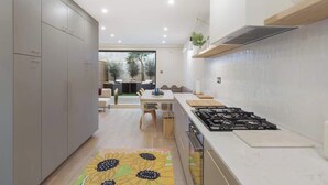 Een moderne keuken met een centraal eiland, inbouwmeubels en een gasfornuis.