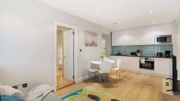 A modern apartment with a dining area, kitchen, and living space.
