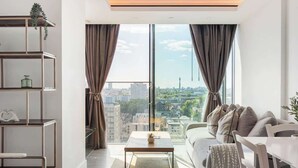 Una sala de estar moderna con vistas a la ciudad, un sofá, una mesa de centro y una estantería.