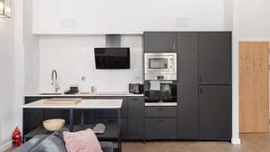 Eine kompakte Küche mit Mikrowelle, Backofen und modernen Schränken.