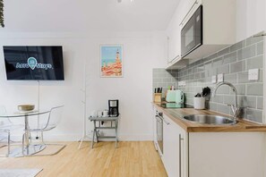 A modern kitchen with a microwave, sink, and a coffee maker on a small table. - Superb 1BR w/AC - Chelsea (Greater London)