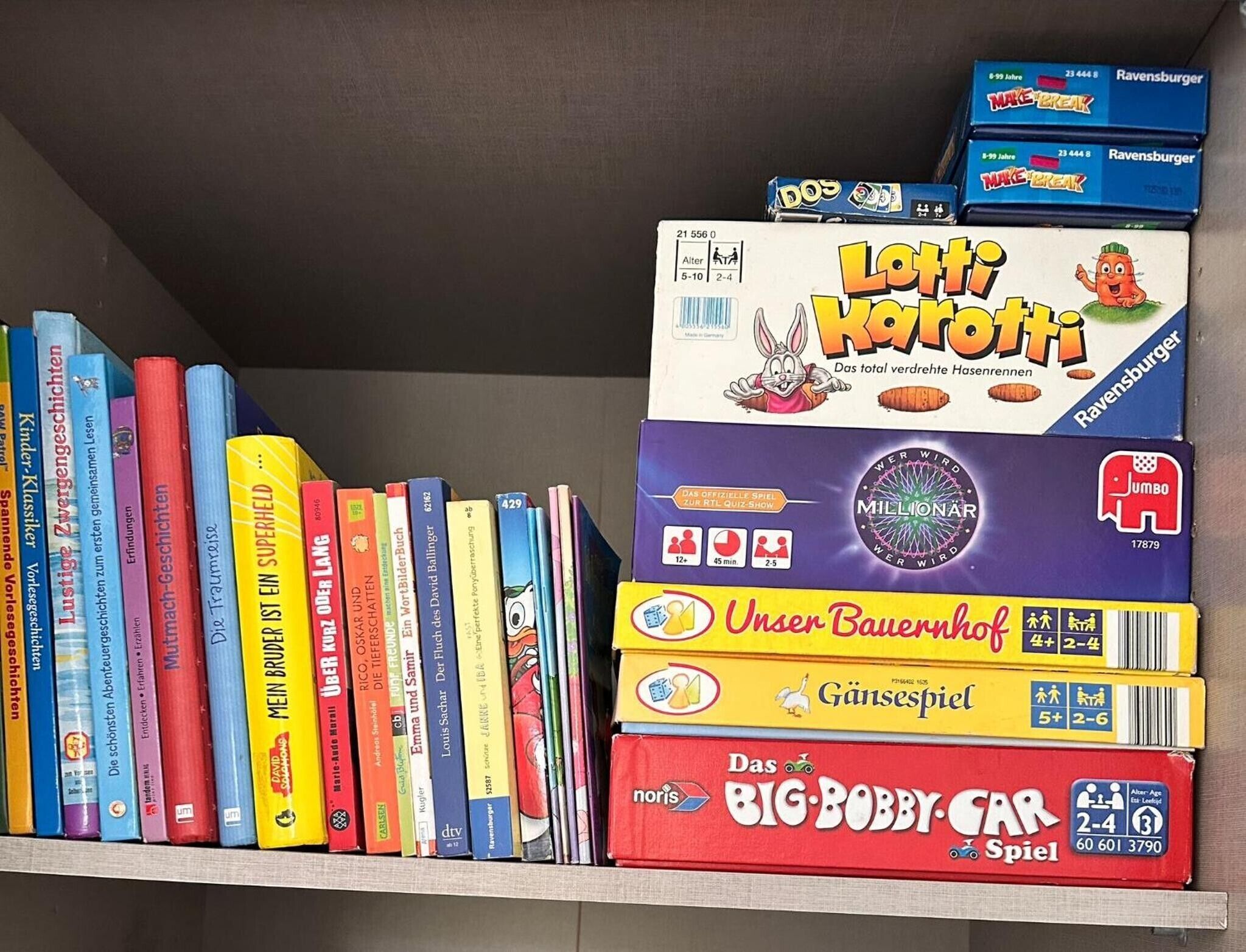 Ein Bücherregal mit verschiedenen Büchern und Gesellschaftsspielen.