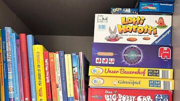 Ein Bücherregal mit verschiedenen Büchern und Gesellschaftsspielen.
