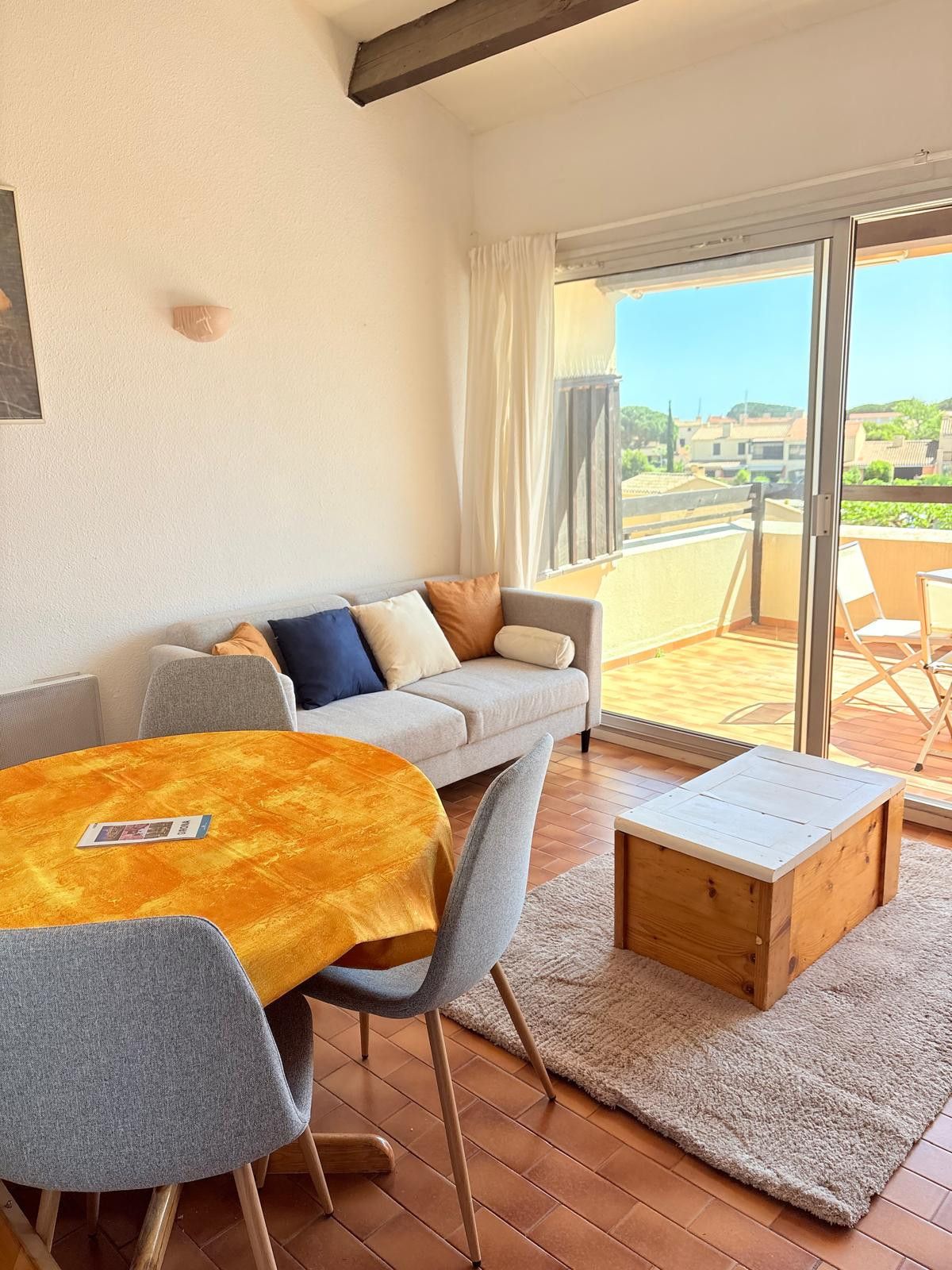 Un espacio de sala acogedor con un sofá, una mesita de madera y vistas al exterior.