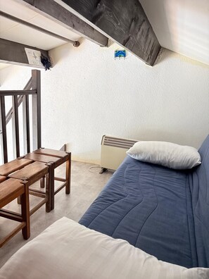 A small, compact room with a wooden bench, a blue sofa, and a white radiator. - St Cyprien, superb bright apartment with large terrace (Saint-Cyprien)