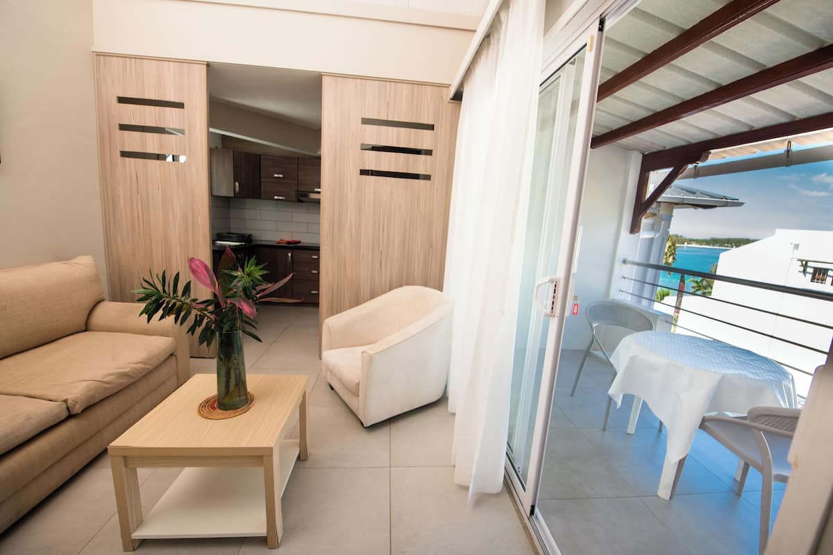 Un salon moderne comprenant un canapé, une table basse et un coin repas avec une table et des chaises.