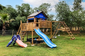 A wooden play structure with a slide and climbing elements. - Apartment 'Cottage 1' with Shared Pool, Wi-Fi and Air Conditioning (Alcácer do Sal)