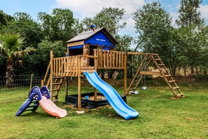 A wooden play structure with a slide and climbing elements. - Apartment 'Cottage 3' with Shared Pool, Wi-Fi and Air Conditioning (Alcácer do Sal)