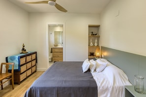 A bedroom with a bed, a desk, a chair, a wardrobe, a mirror, and a shelf with decorative items. - Villa Greta with Mountain Views, Private Pool, and Wi-Fi (Vilanant)