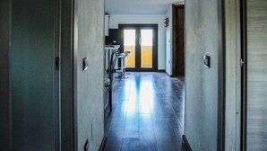 A hallway with a door leading to a room with a view. - Blue Nest Ottava (Sassari)