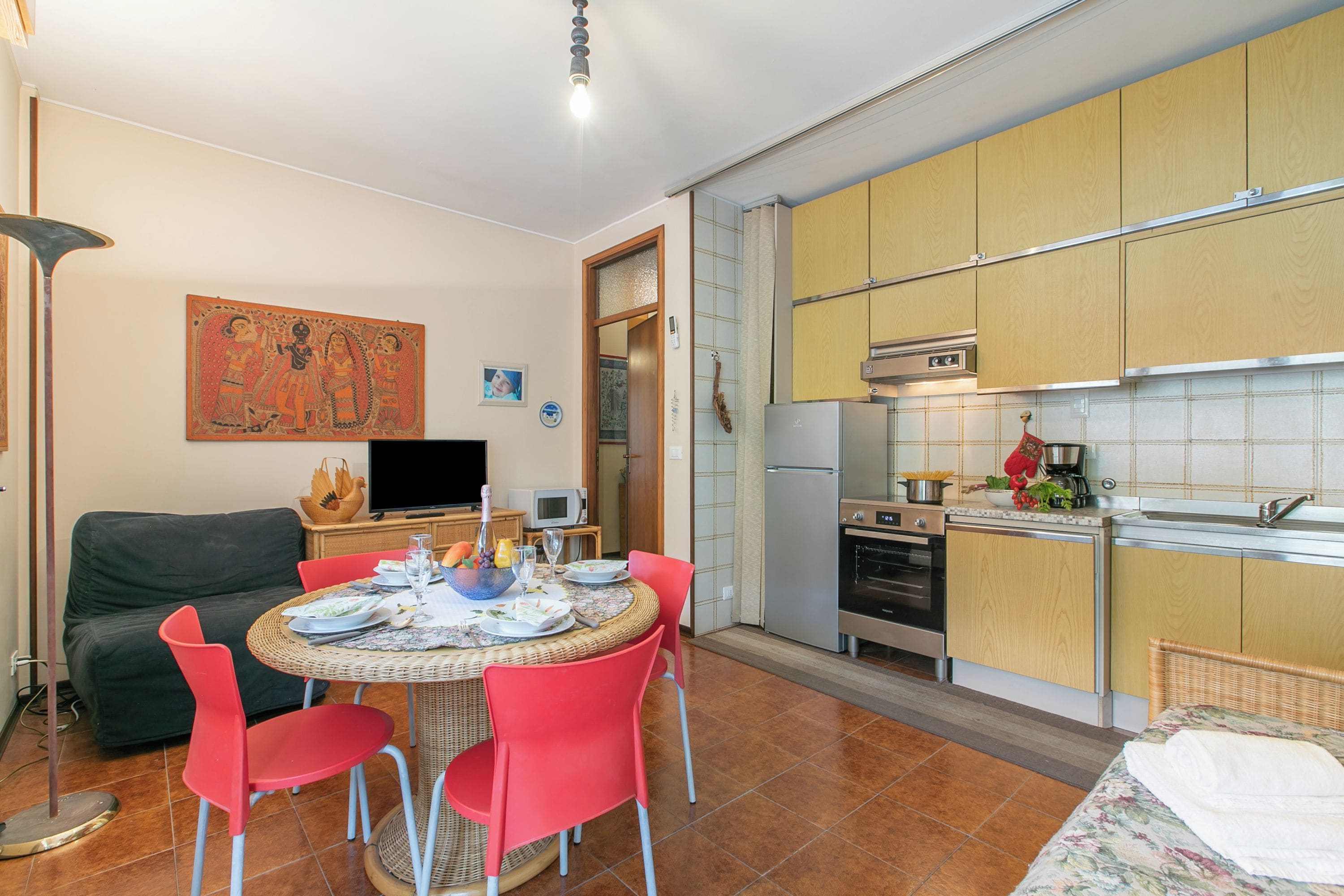 Um espaço compacto com área de refeições, cozinha e sofá.