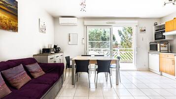 Una cucina moderna con un tavolo da pranzo, sedie e un divano viola.