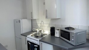 A compact kitchen with a stove, oven, microwave, and a toaster. - Apartment Sleeps 2 - Free Street Parking (Gateshead)