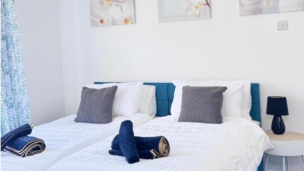 A hotel room with a bed, pillows, a lamp, and artwork on the wall. - Apartment Sleeps 2 - Free Street Parking (Gateshead)