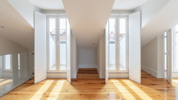 A spacious hallway with wooden flooring, large windows, and a high ceiling. - Graça Duplex With A View by Homing (Lisbon)