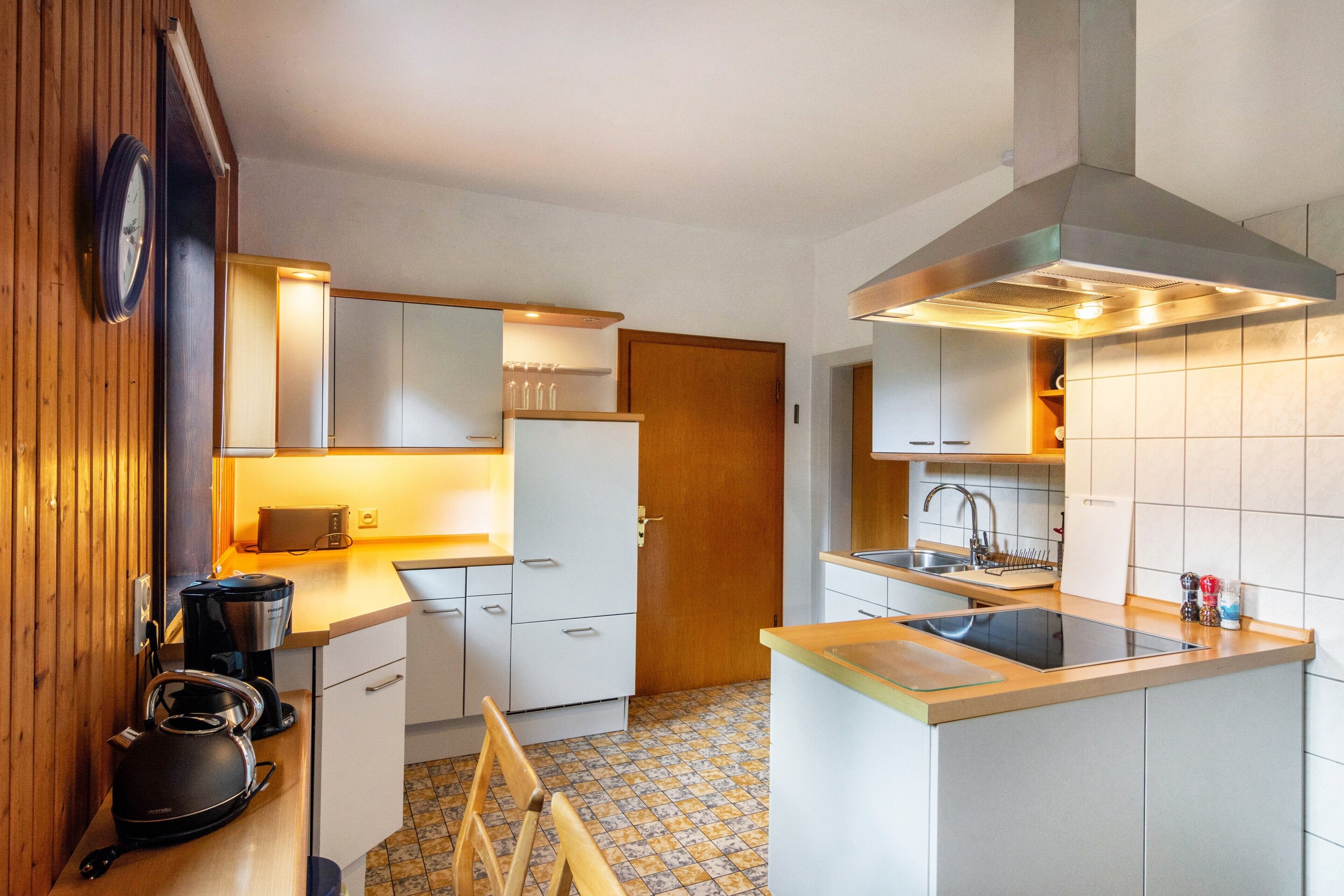 A compact kitchen with a stove, sink, and cabinets.