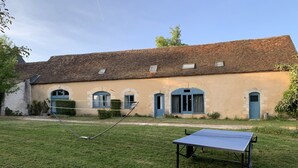 Un edificio con tetto in mattoni, finestre ad arco e un campo da tennis.