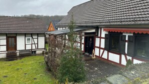 A traditional half-timbered building with a sloped roof, a wooden door, and a small porch area. - Holiday Home 'Ferienhaus Am Ritzberg' with Private Terrace, Shared Garden and Wi-Fi (Beverungen)