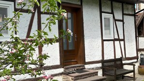A traditional half-timbered house with a wooden door, stone steps, and a bench outside. - Holiday Home 'Ferienhaus Am Ritzberg' with Private Terrace, Shared Garden and Wi-Fi (Beverungen)