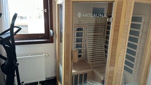 A sauna room with a wooden structure, a window, and a radiator. - Holiday Home 'Ferienhaus Am Ritzberg' with Private Terrace, Shared Garden and Wi-Fi (Beverungen)