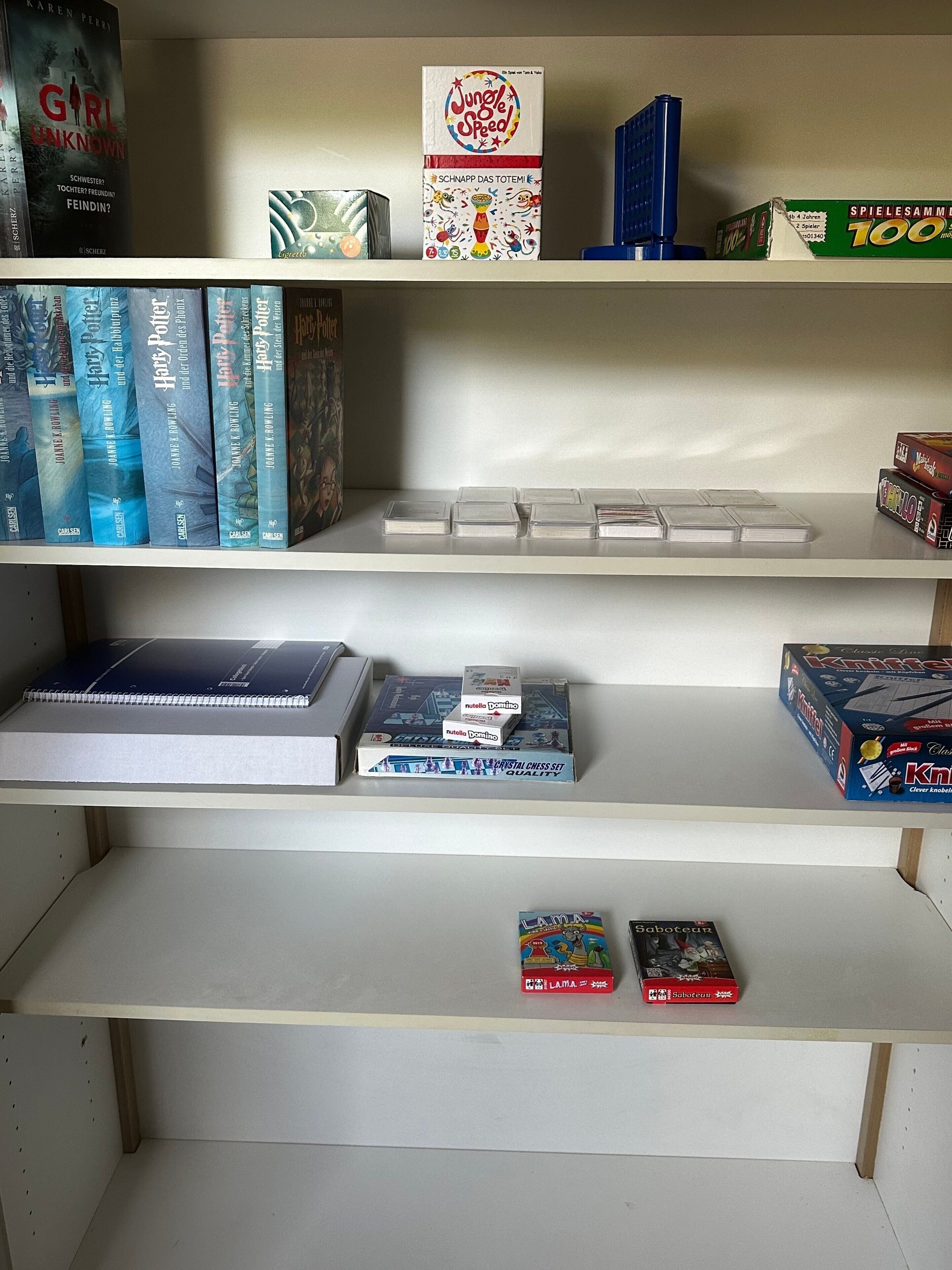 Ein Bücherregal mit verschiedenen Büchern und Gesellschaftsspielen.