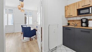 Een moderne keuken met een magnetron, koffiezetapparaat en houten kastjes.