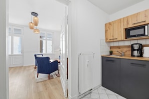 Eine moderne Küche mit Mikrowelle, Kaffeemaschine und Holzschränken.