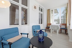 Ein Zimmer mit einem blauen Sofa, einem runden Tisch und einer Laterne.