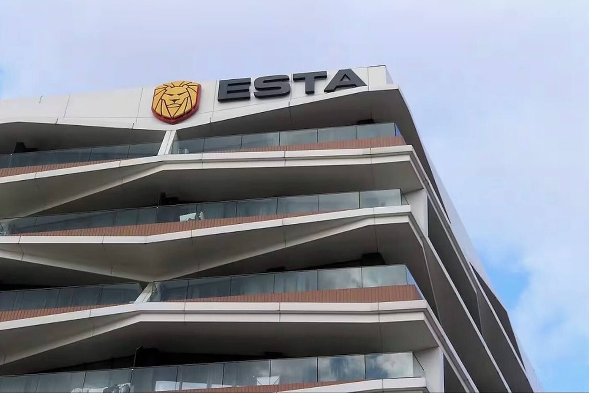 Un edificio de varios pisos con un logotipo de león y la palabra 'ESTA' en la fachada.