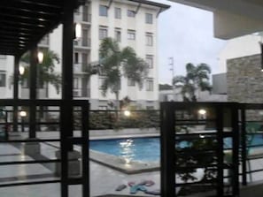 A pool area with a view of a multi-story building in the background. - One Metropolitan Place (Pasay)