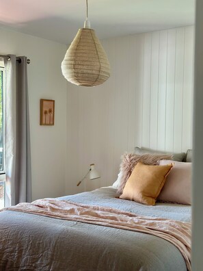 A bedroom with a bed, a hanging light fixture, a bedside table with a lamp, and a wall-mounted picture. - On the beach, Cowes, Phillip Island, Sleeps (Cowes)