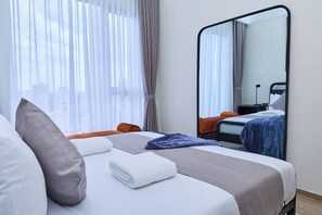 Habitación de hotel con cama, un espejo grande y vistas a la ciudad desde la ventana.