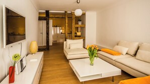 Un salon moderne avec un canapé, une table basse et un téléviseur fixé au mur.