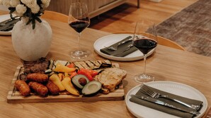 A dining table with a variety of food, wine glasses, and cutlery. - Leisure Lake - 3BR Home, Hot Tub, Paddle boats (Scotrun)