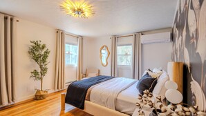 A bedroom with a bed, a plant, a mirror, and a window. - Leisure Lake - 3BR Home, Hot Tub, Paddle boats (Scotrun)