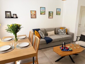 A modern living room with a dining area, a sofa set, and a coffee table. - Charming welcoming village house - 5 guests (La Chapelle-Saint-Martin-en-Plaine)
