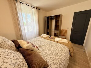 A bedroom with a bed, a wardrobe, a chair, and a door. - Charming welcoming village house - 5 guests (La Chapelle-Saint-Martin-en-Plaine)