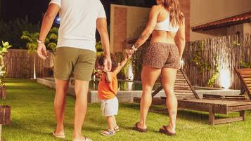 A family walking on a grassy lawn at night.
