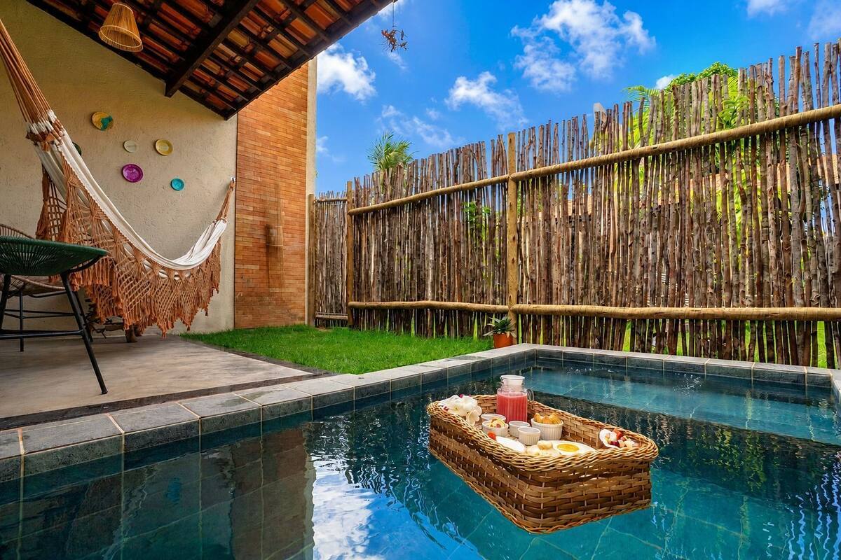 Une piscine avec un panier flottant rempli de nourriture, un hamac et une clôture en bois.