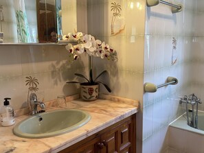 A bathroom with a sink, mirror, shower, and decorative tiles. - Villa with private pool and AC - 10 guests (Miami Playa)