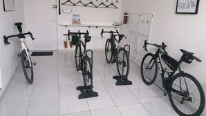A room with bicycles parked against the wall, a clock, and a framed quote on the wall. - Charming cottage with parking - 2 guests in village center (Choloy-Ménillot)
