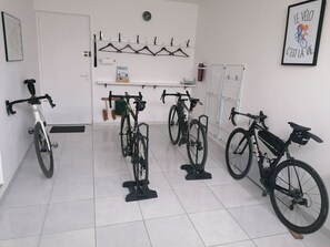 Ein Zimmer mit Fahrrädern, die an der Wand lehnen, einer Uhr und einem gerahmten Zitat an der Wand.