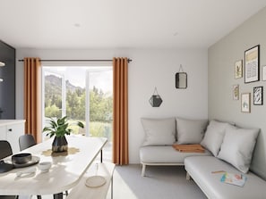 Una sala de estar moderna con un sofá, una mesa de comedor con una planta y vistas al exterior.