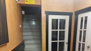 Una escalera conduce a un rellano con una puerta y un letrero encima.