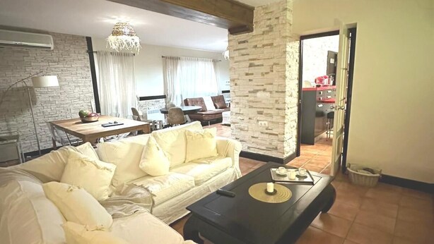 Una sala de estar con un sofá, una mesa de centro y una zona de comedor con una mesa y sillas.