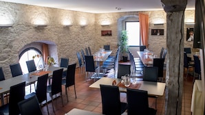 A restaurant with stone walls, multiple tables, and chairs. - Room 'Single Room Comfort 102' with Wi-Fi (Schlitz)