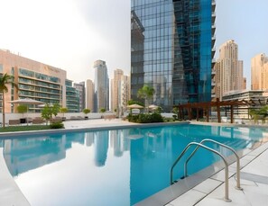 Ein Schwimmbad mit freiem Blick auf umliegende Hochhäuser und moderner Architektur.