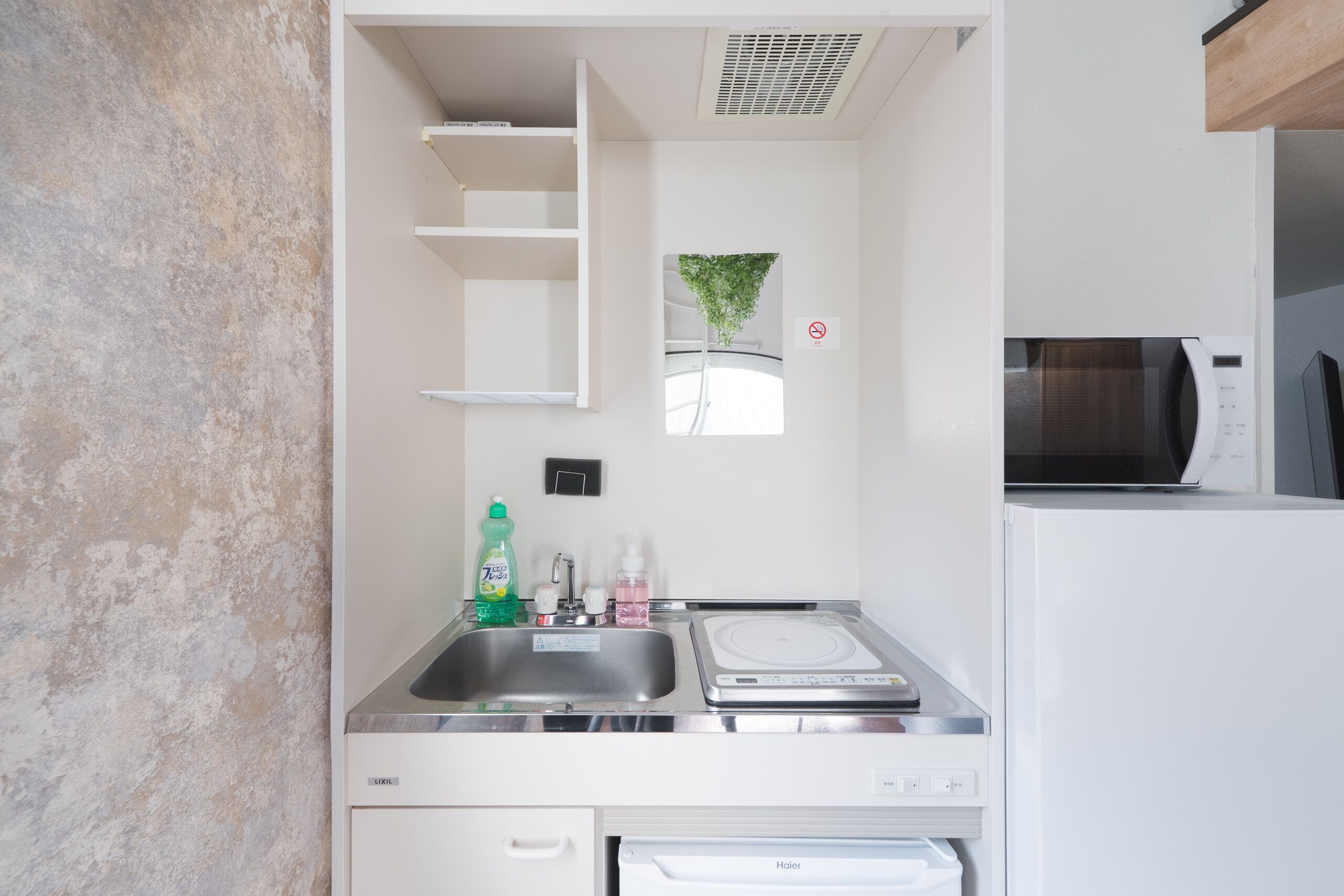 A compact kitchen with a dishwasher, a microwave, and a sink.
