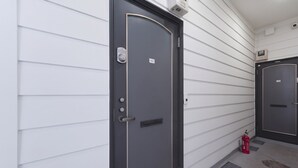 Un couloir avec deux portes, l’une portant le numéro 101 et l’autre le numéro 105, toutes deux dotées de poignées extérieures et de claviers à code.
